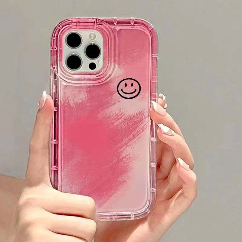 a woman holding a pink iphone case with a smiley face on it
