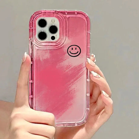 A woman holding a pink iphone case with a smiley face on it