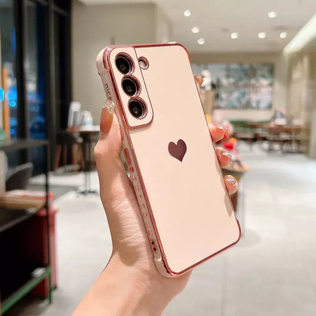 a woman holding up a pink iphone case