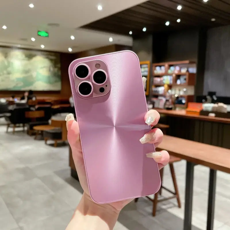 a woman holding up a pink iphone case