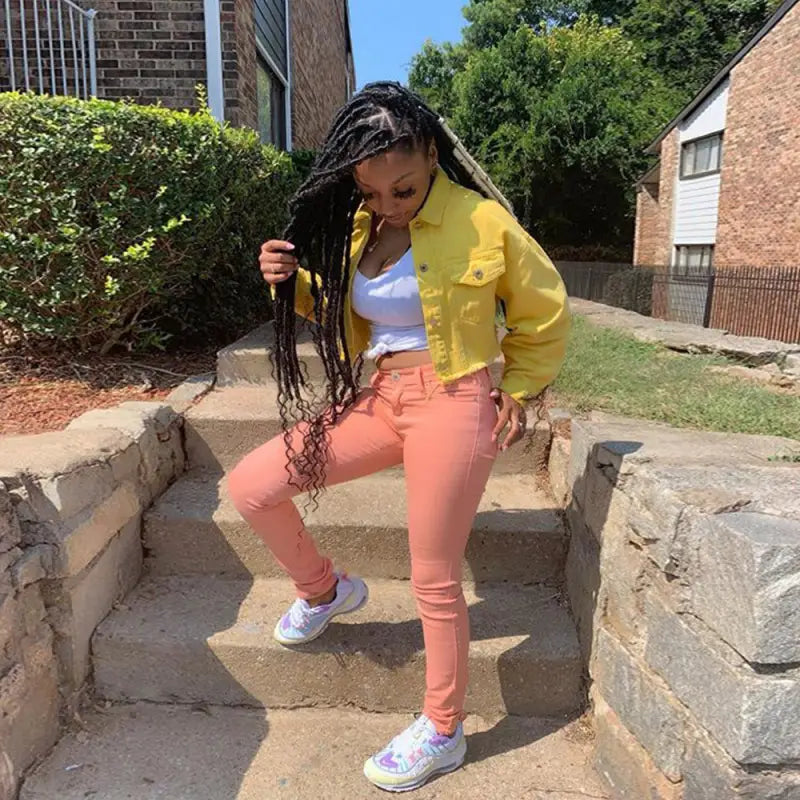 araffe woman with dreadlocks standing on steps in front of a brick building