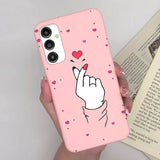 a woman holding a pink phone case with a heart on it