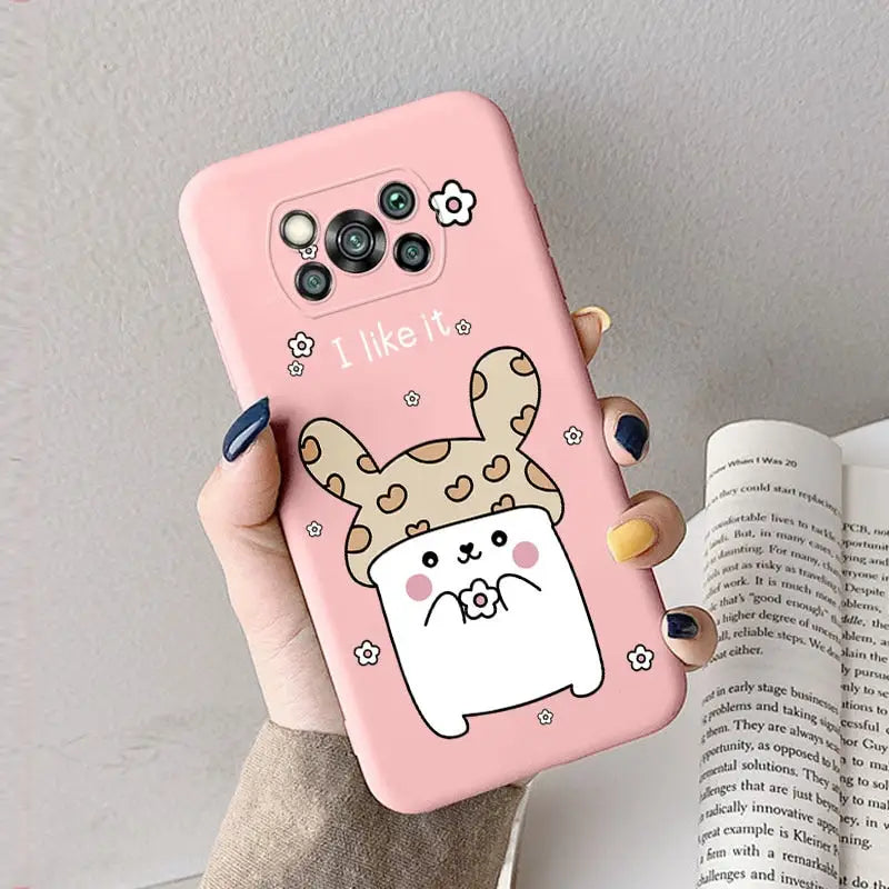 a woman holding a pink phone case with a cartoon cat