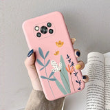 a woman holding a pink phone case with flowers on it