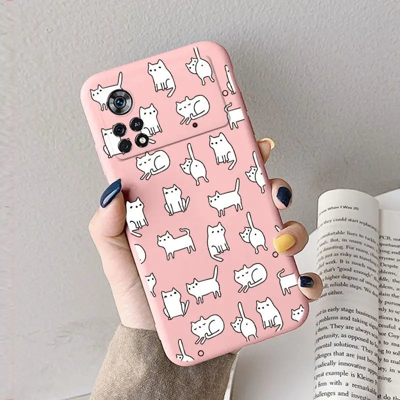 a woman holding a pink phone case with white cats on it