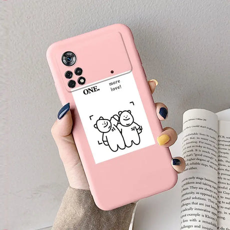 A woman holding a pink phone case with a cartoon cat on it