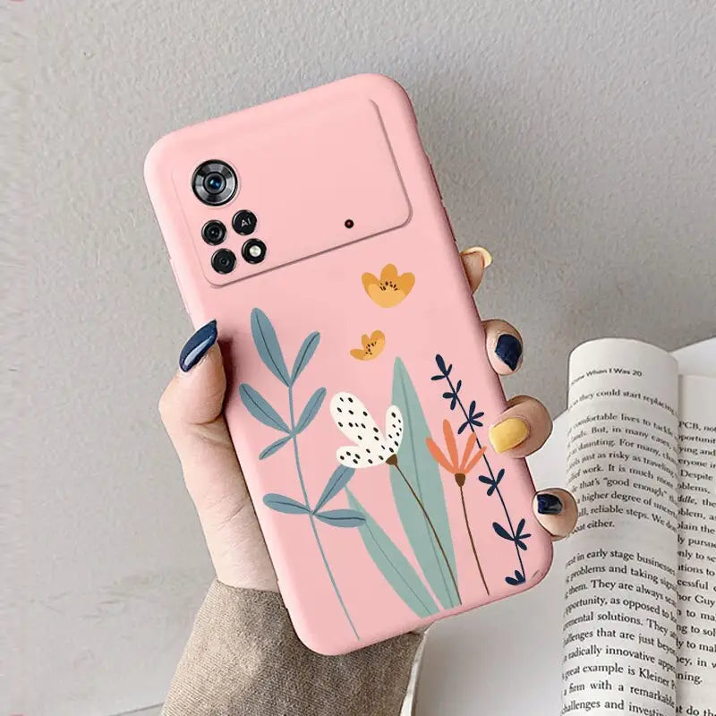 a woman holding a pink phone case with flowers on it