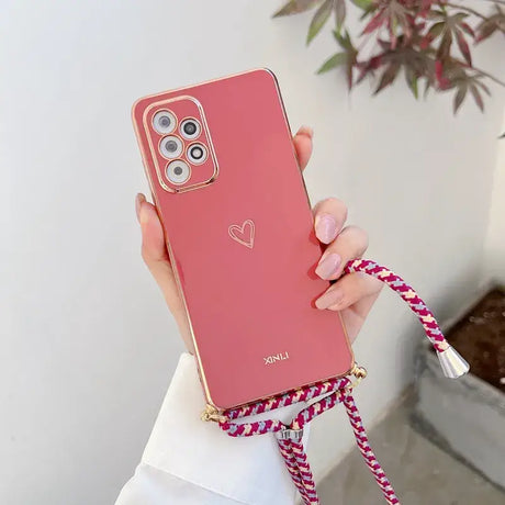 A woman holding a pink phone case with a heart on it