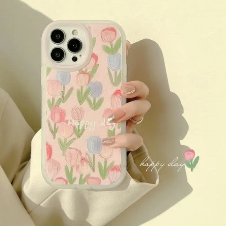 A woman holding a pink phone case with flowers on it