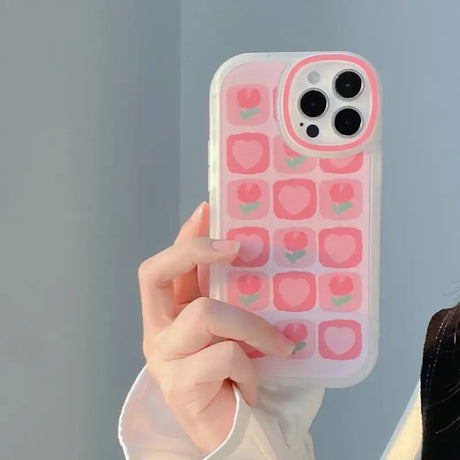 A woman holding a pink phone case with a heart pattern