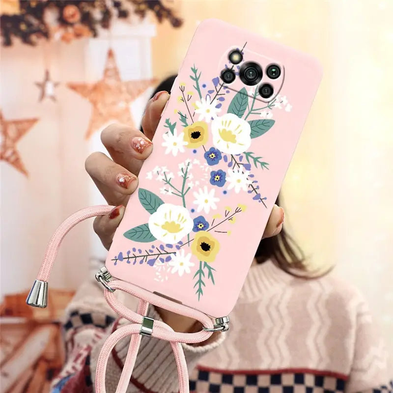 a woman holding a pink phone case with flowers on it