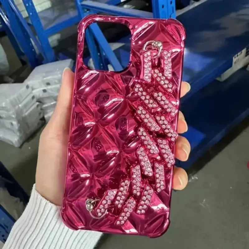 a woman holding a pink phone case with diamonds