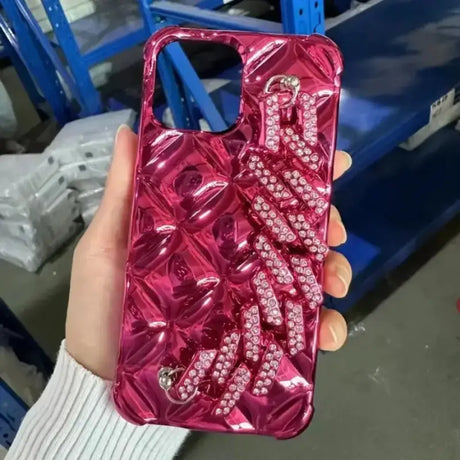 A woman holding a pink phone case with diamonds