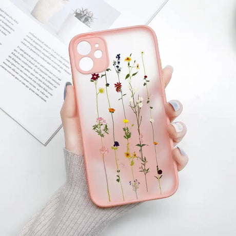 A woman holding a pink phone case with flowers on it