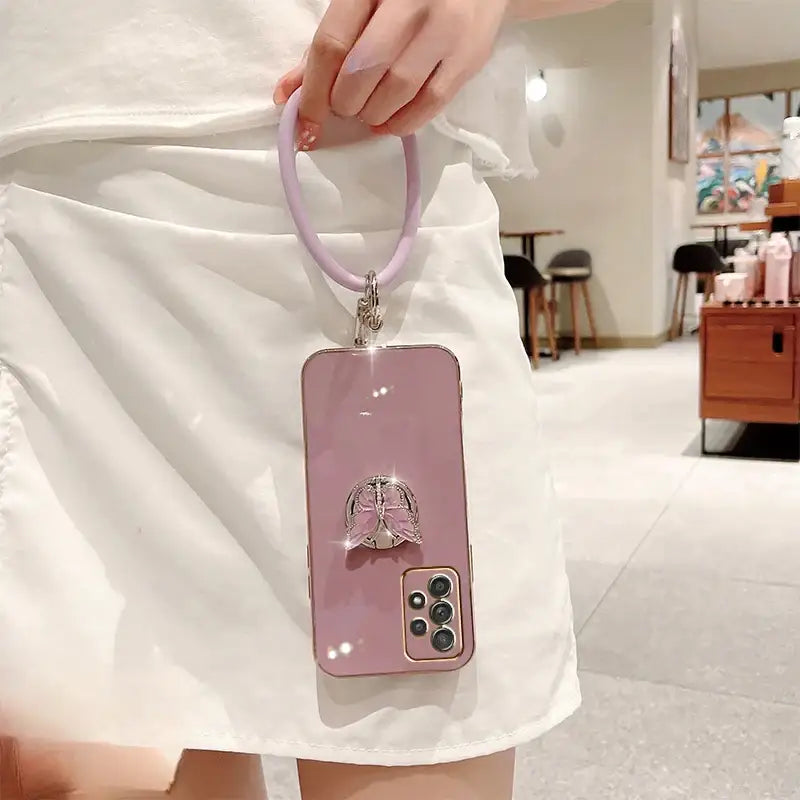 a woman holding a pink phone case with a pink strap