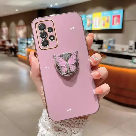 A woman holding a pink phone case with a pink butterfly on it