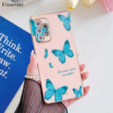 a woman holding a pink phone case with blue butterflies on it