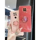a woman holding a pink phone case with a ring on it