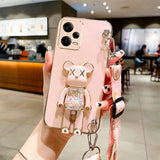 a woman holding a pink phone case with a keychai
