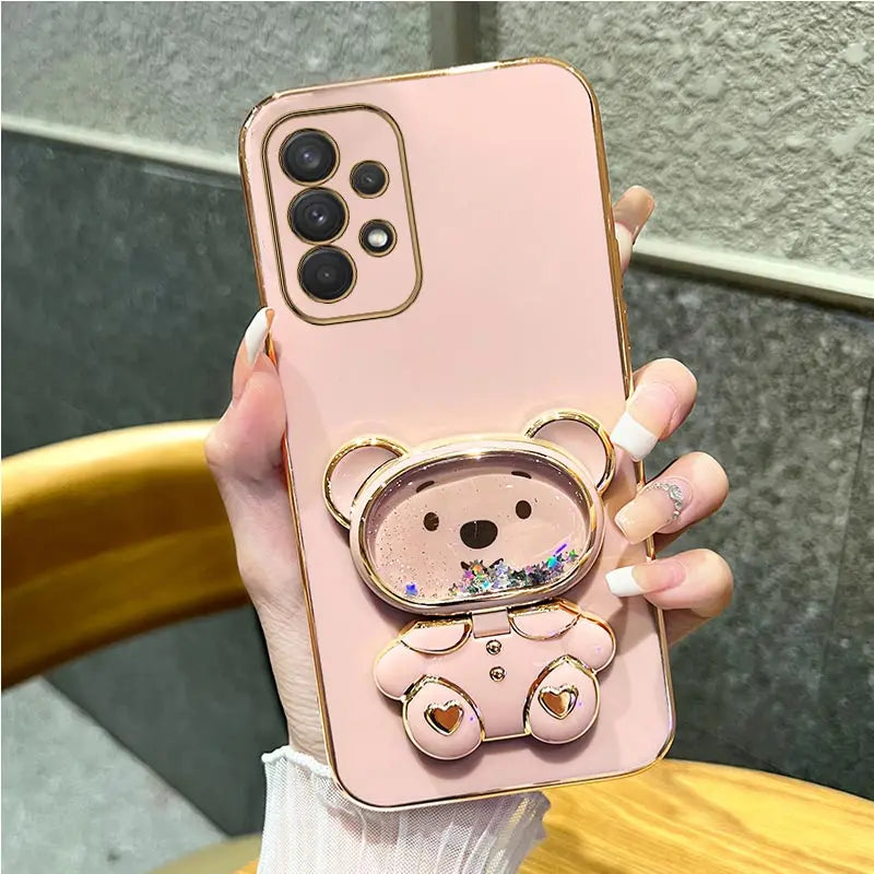 a woman holding a pink phone case with a bear