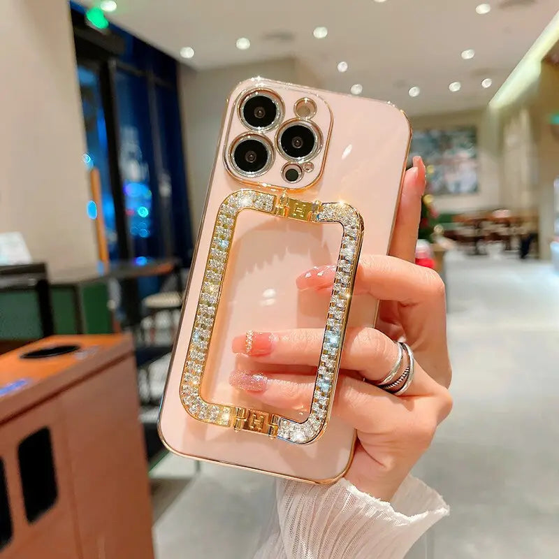 a woman holding a pink phone case with a diamond ring