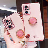 a woman holding a pink phone case with a ring