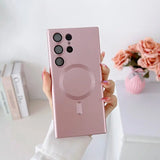 a woman holding up a pink phone case