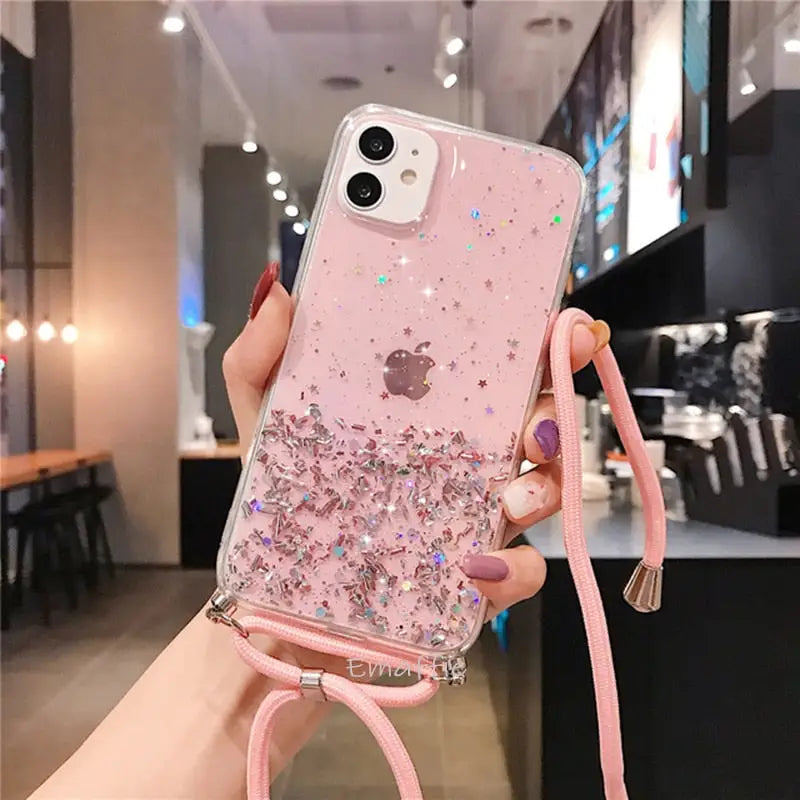 a woman holding a pink phone case with glitters