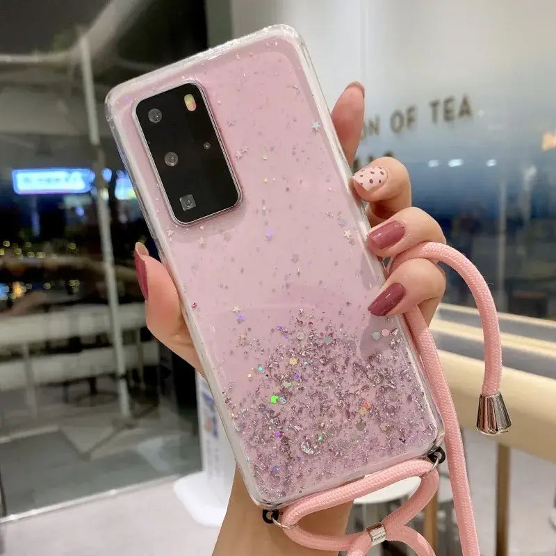 a woman holding a pink phone case with glitter