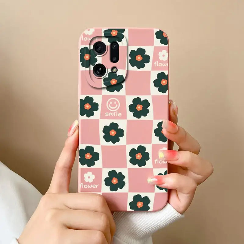 a woman holding a pink phone case with flowers on it