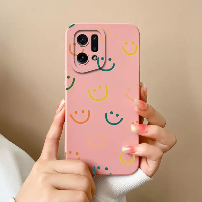a woman holding a pink phone case with smiley faces