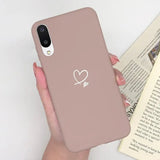a woman holding a pink phone case with a heart on it