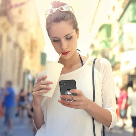 a woman with pink hair is looking at her phone