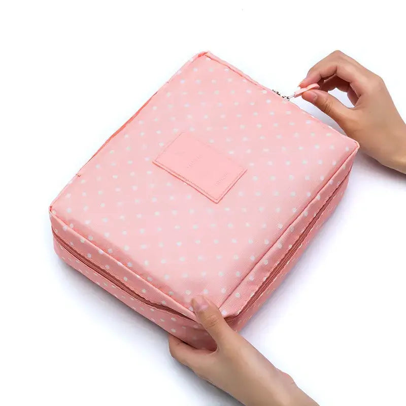 a woman holding a pink polka dot print cosmetic bag