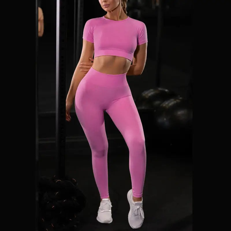 a woman in pink sports gear is standing in front of a mirror