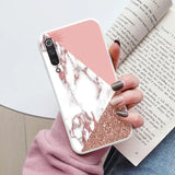 a woman holding a pink and white marble phone case