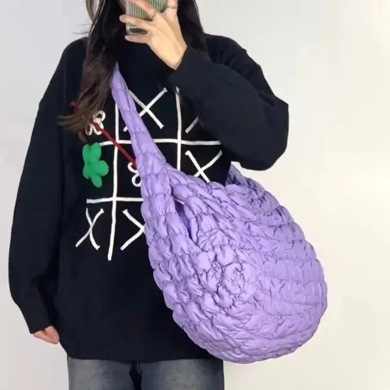 a woman holding a purple bag with a green ball