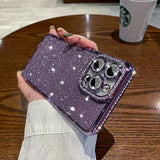 a woman holding a purple glitter phone case