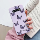 a woman holding a purple phone case with butterflies on it