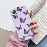 a woman holding a purple phone case with butterflies on it
