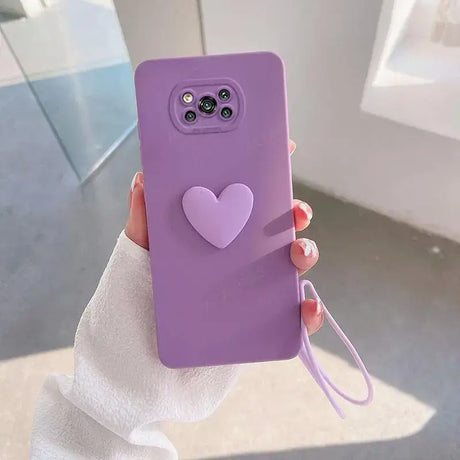 A woman holding a purple phone case with a heart on it