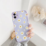a woman holding a purple phone case with white daisies on it