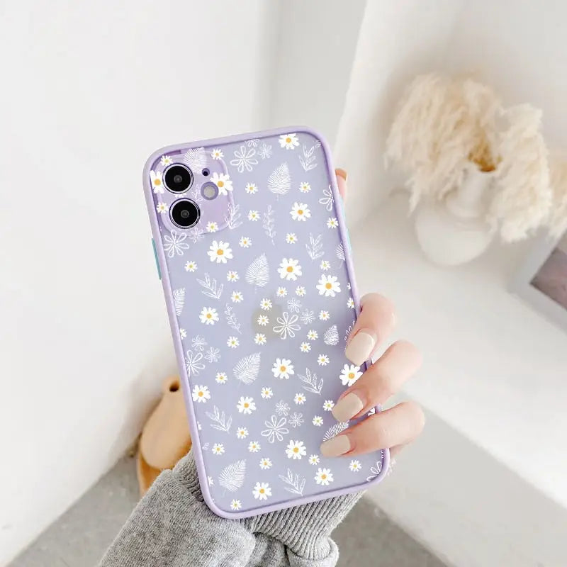 a woman holding a purple phone case with white flowers on it