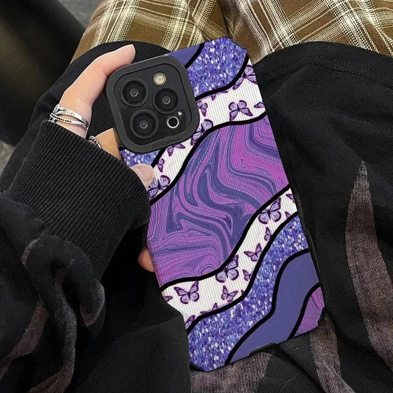 a woman holding a purple phone case with a purple and black design