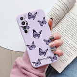 a woman holding a purple phone case with butterflies on it