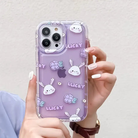 A woman holding a purple phone case with a pattern of rabbits