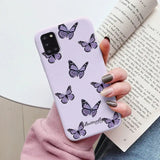 a woman holding a purple phone case with butterflies on it