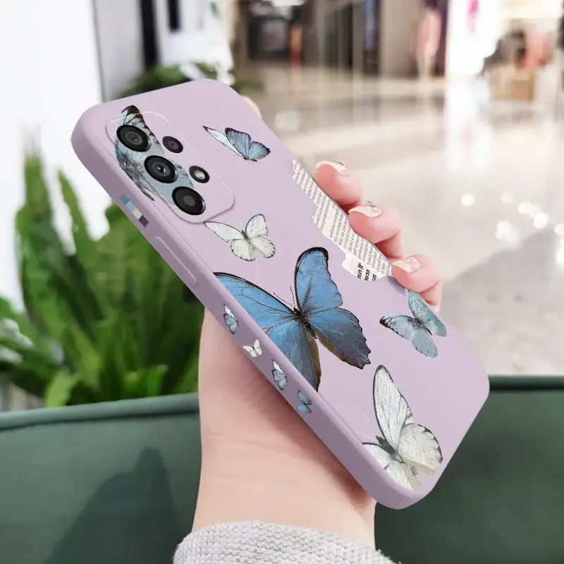 a woman holding a purple phone case with butterflies on it