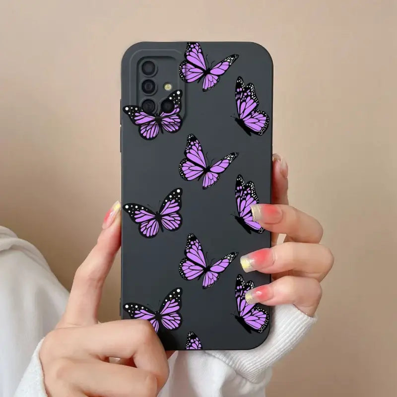 a woman holding a purple phone case with butterflies on it