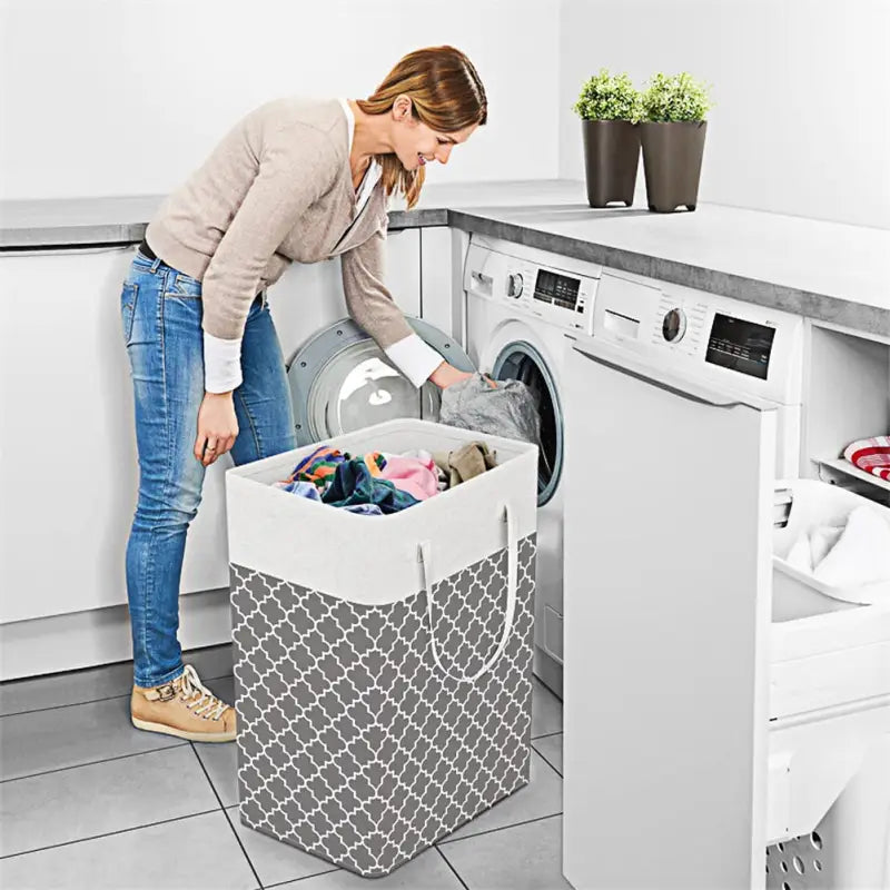 a woman putting a laundry basket into a washing machine